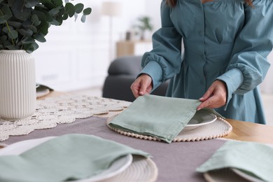 Photo of Woman setting table for dinner at home, closeup