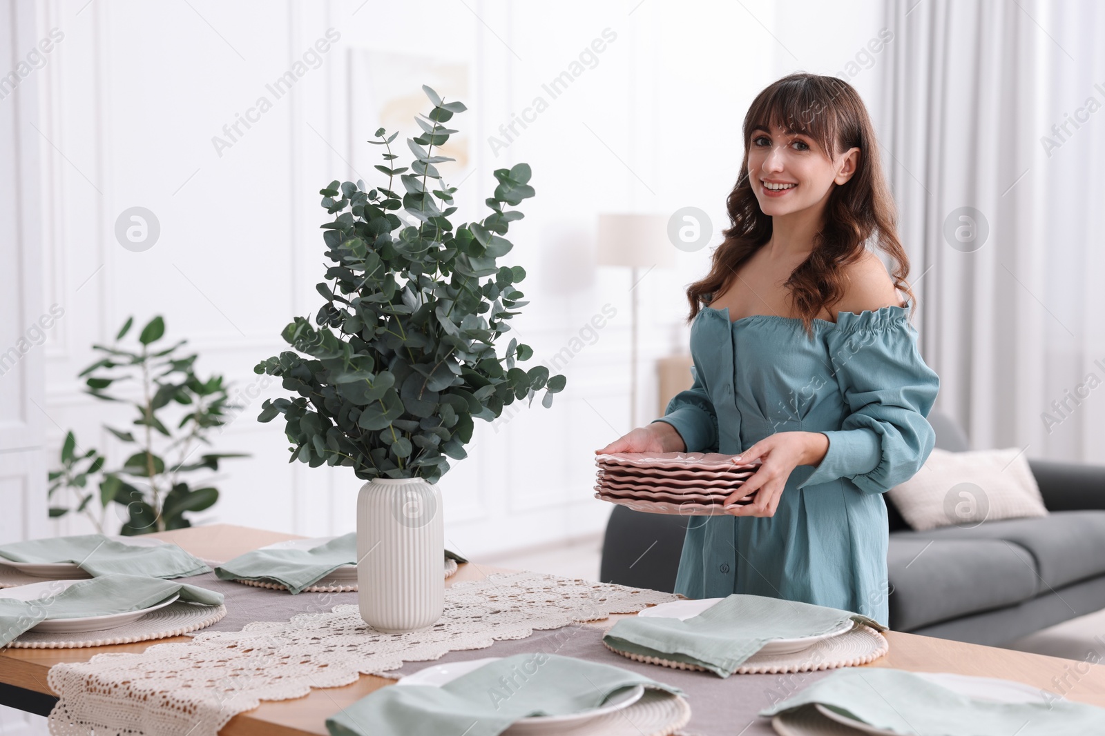 Photo of Woman setting table for dinner at home