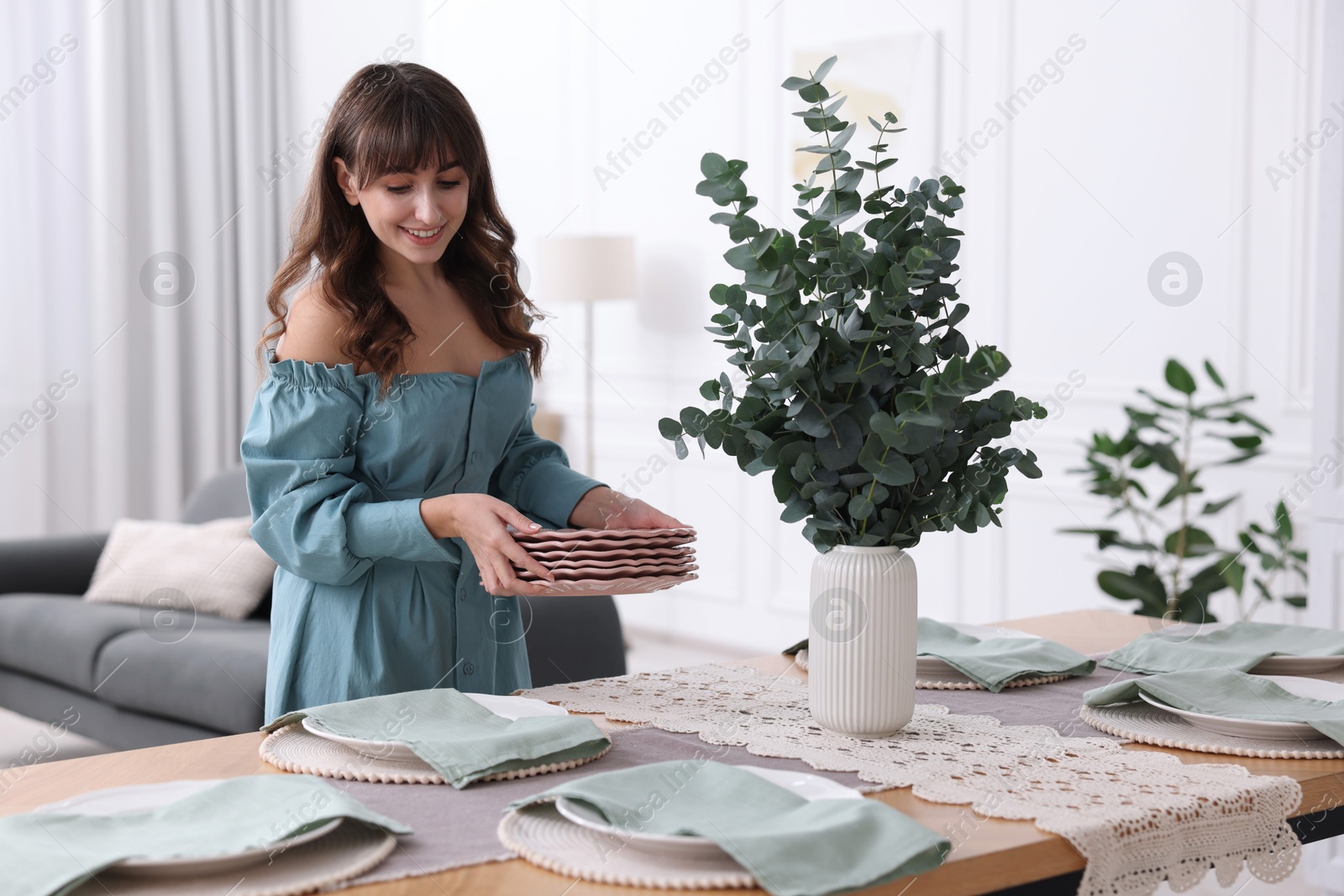 Photo of Woman setting table for dinner at home