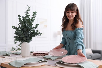 Photo of Woman setting table for dinner at home