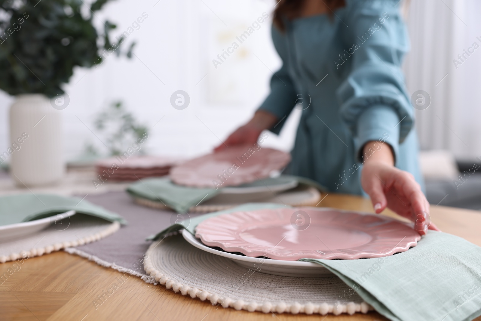 Photo of Woman setting table for dinner at home, closeup. Selective focus