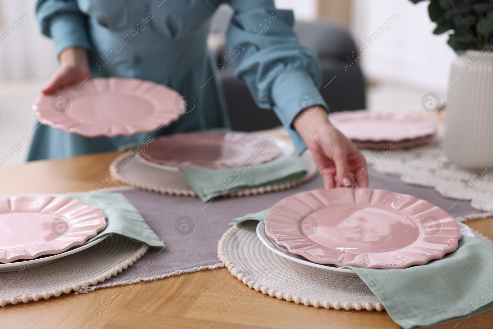 Photo of Woman setting table for dinner at home, closeup