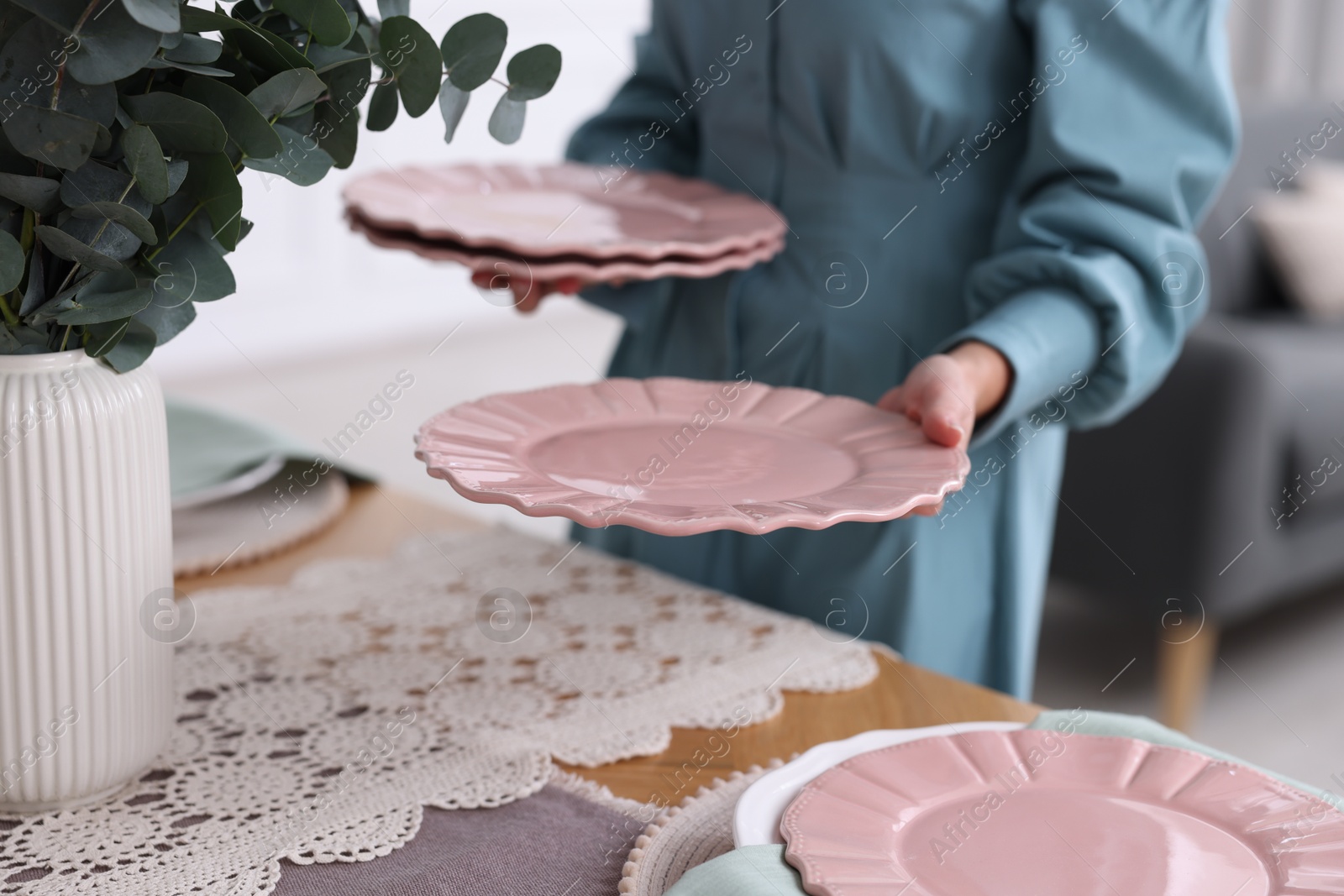 Photo of Woman setting table for dinner at home, closeup