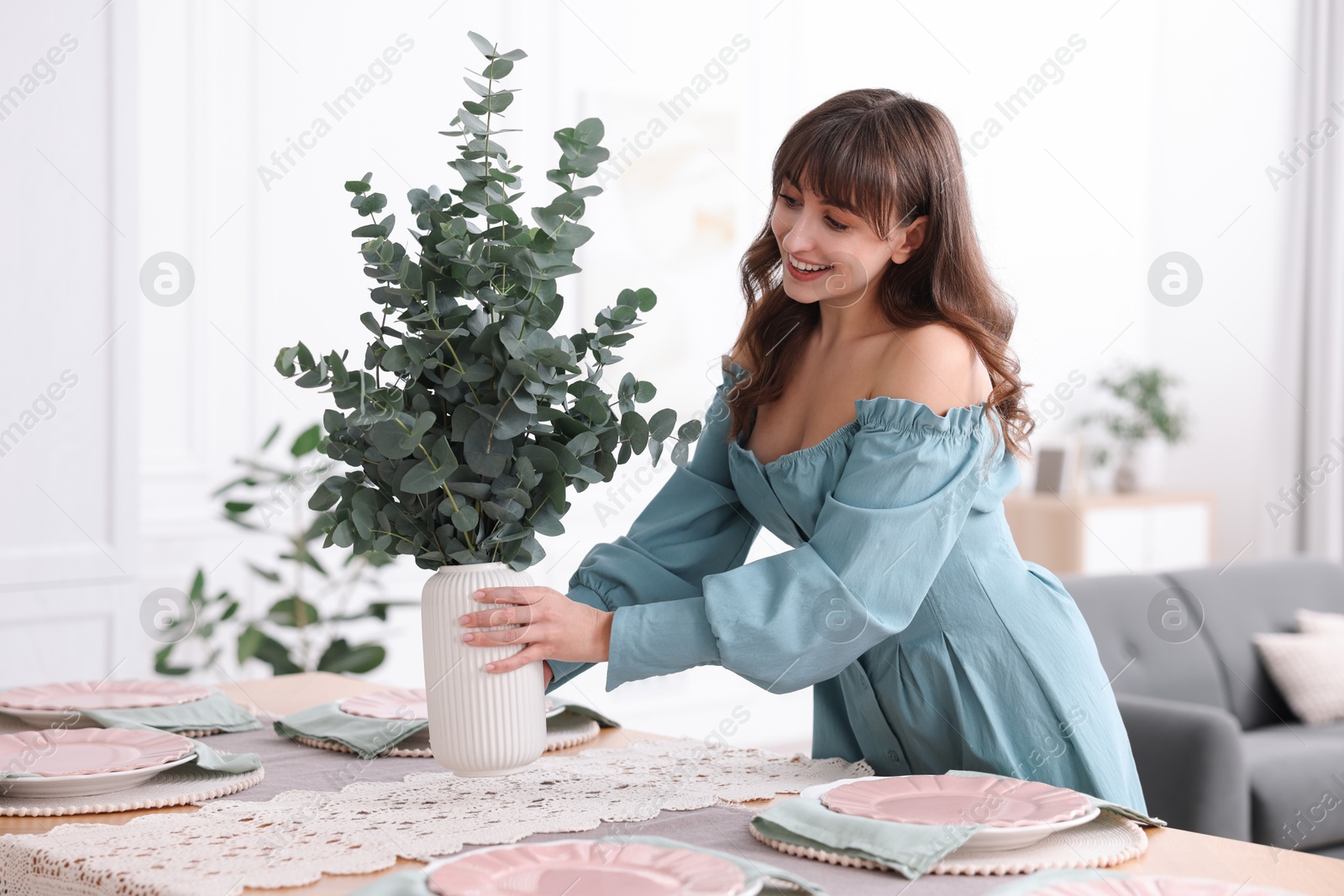 Photo of Woman setting table for dinner at home