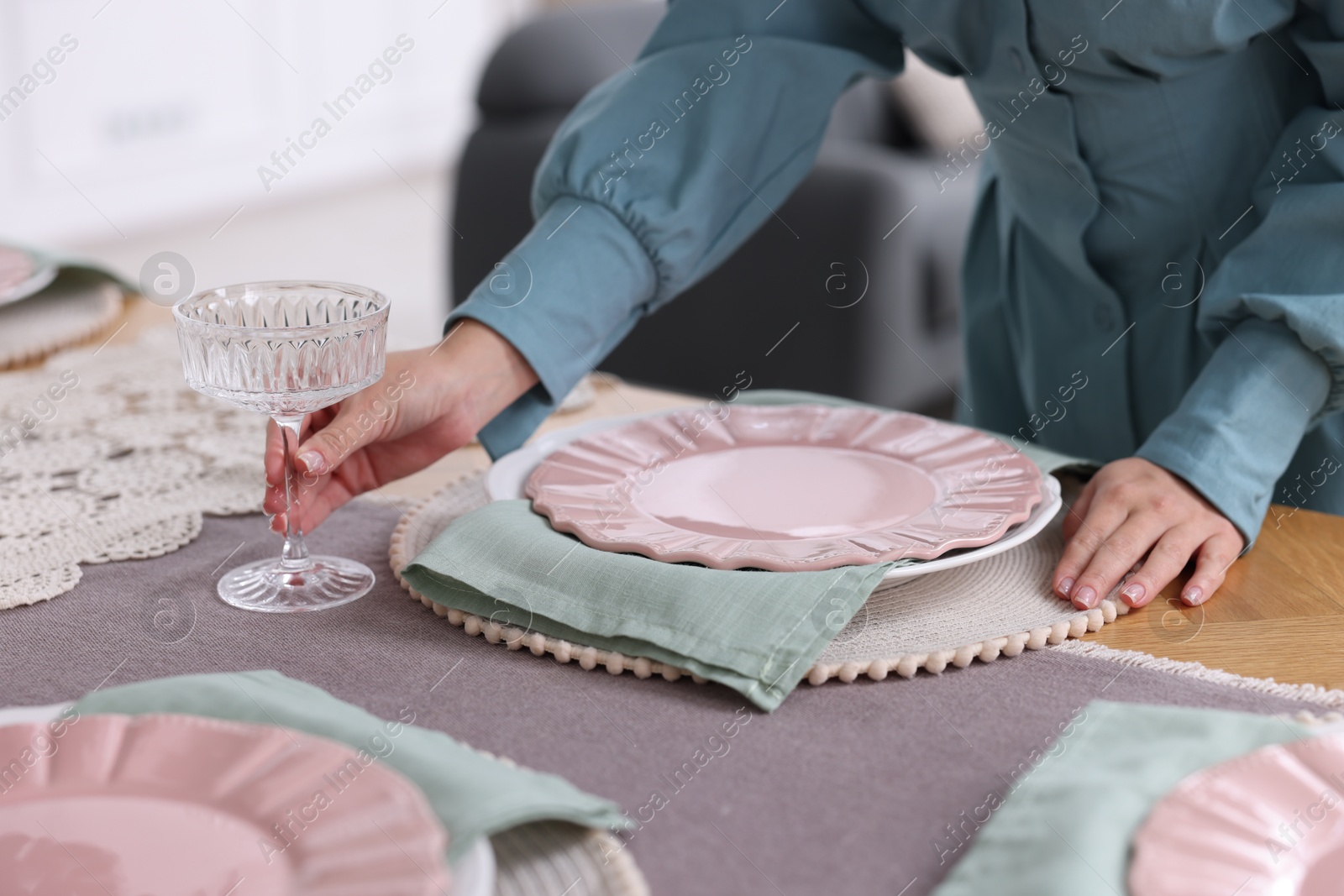 Photo of Woman setting table for dinner at home, closeup