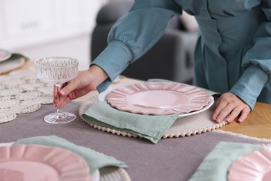 Photo of Woman setting table for dinner at home, closeup