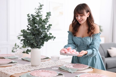 Woman setting table for dinner at home