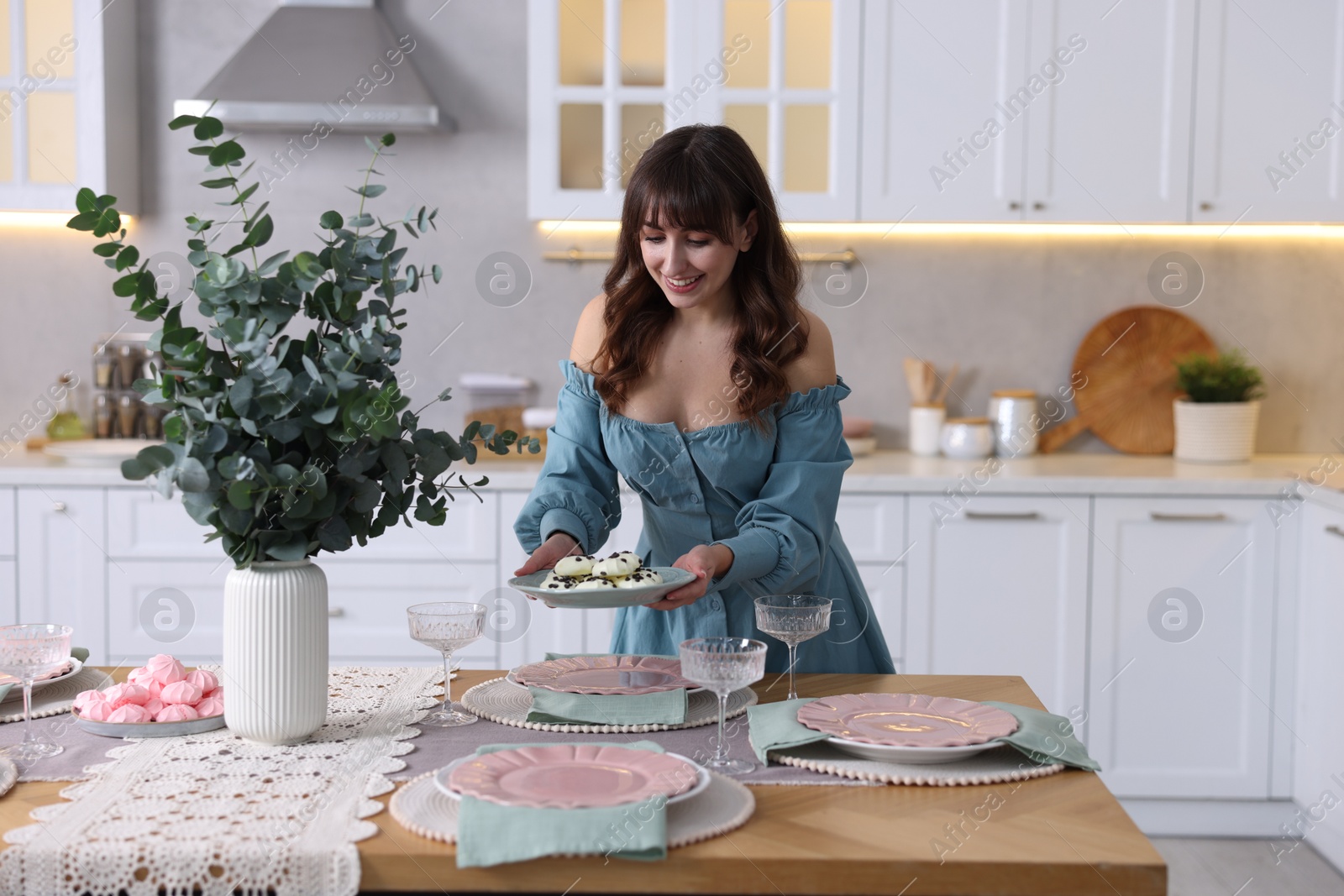 Photo of Woman setting table for dinner at home