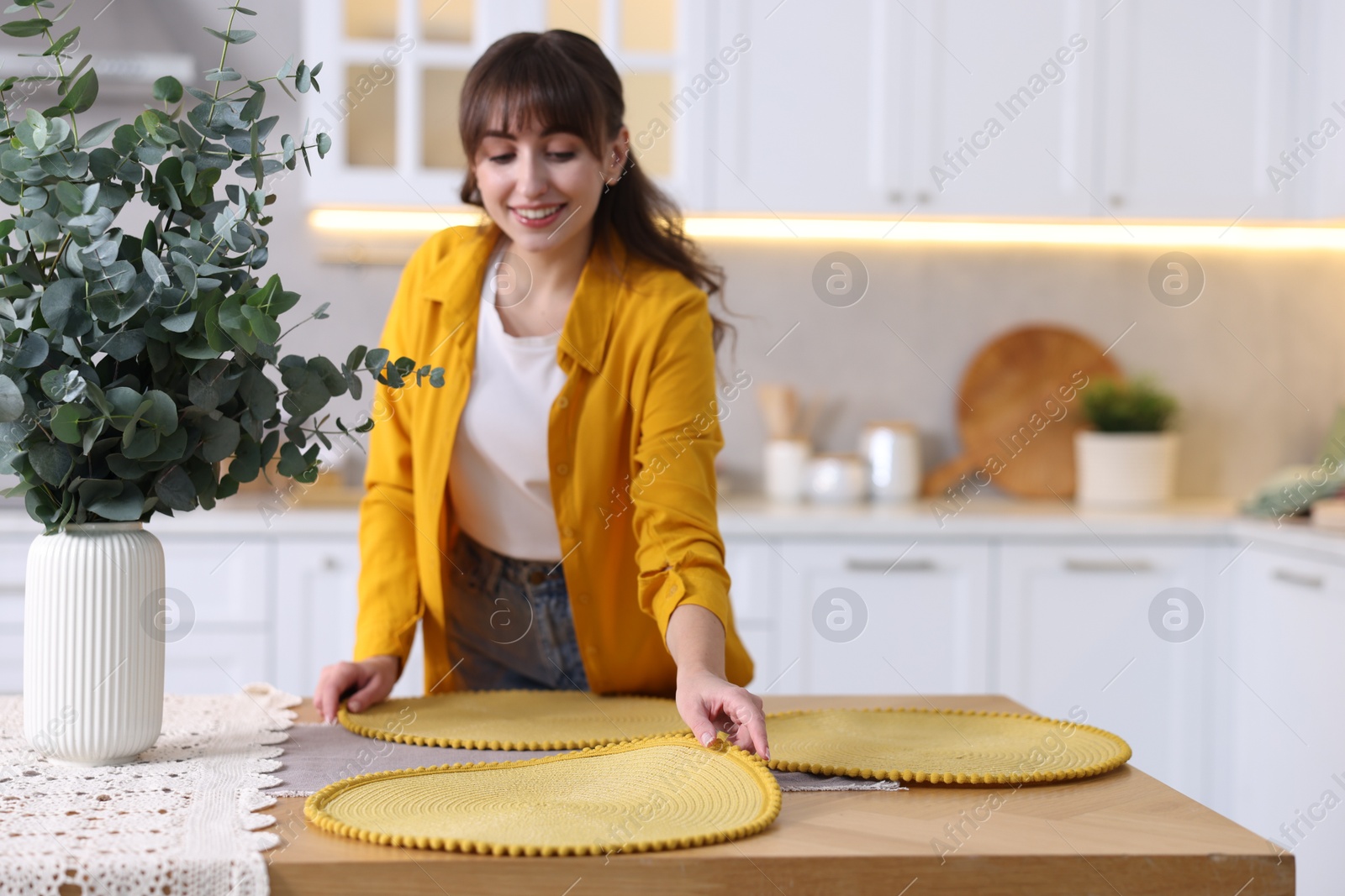 Photo of Woman setting table for dinner at home, space for text