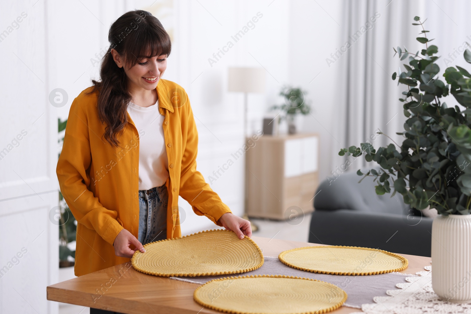 Photo of Woman setting table for dinner at home, space for text