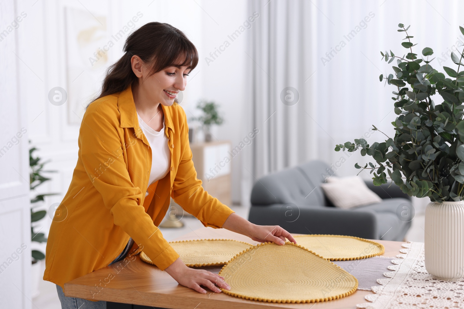 Photo of Woman setting table for dinner at home