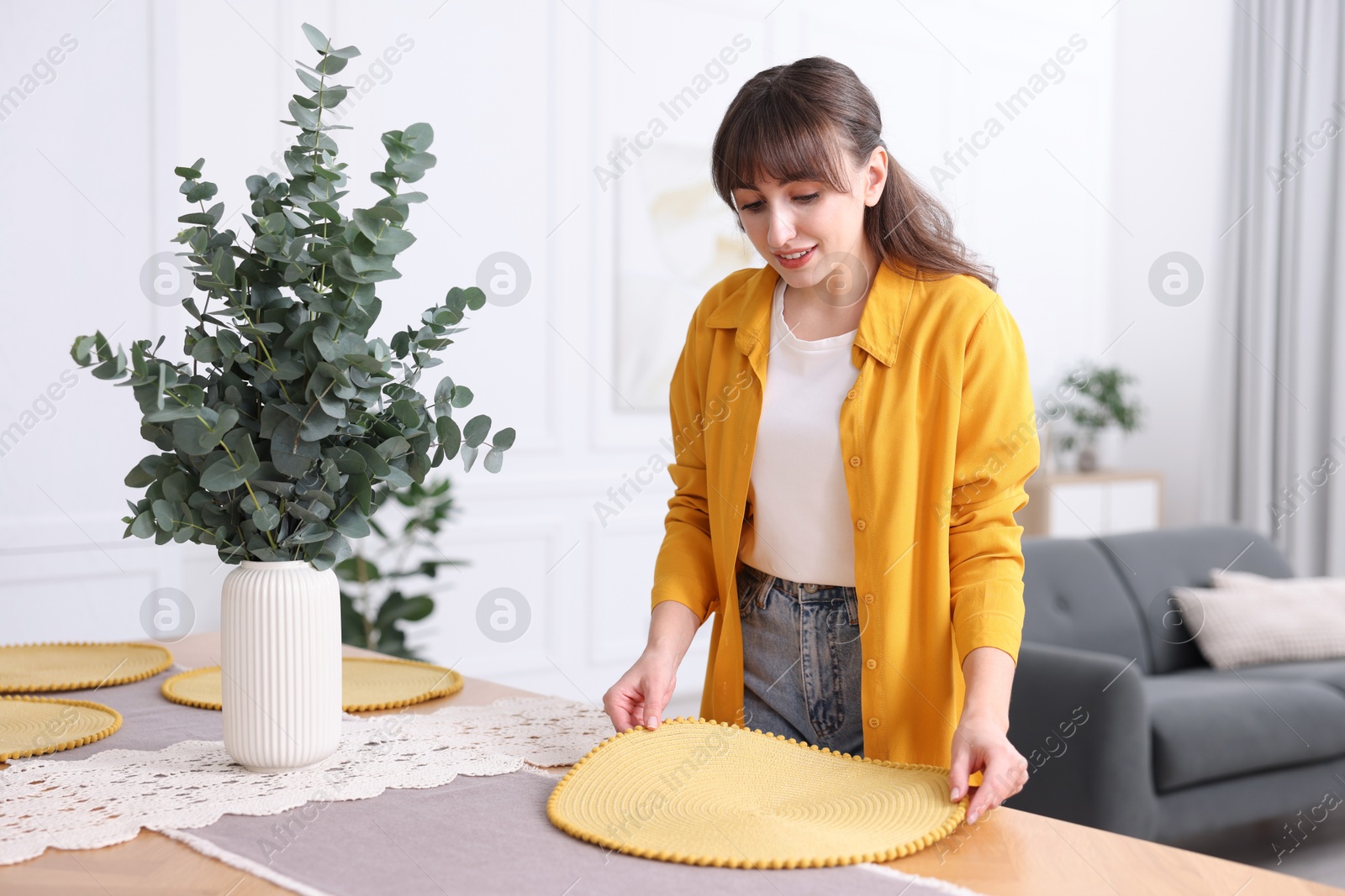 Photo of Woman setting table for dinner at home