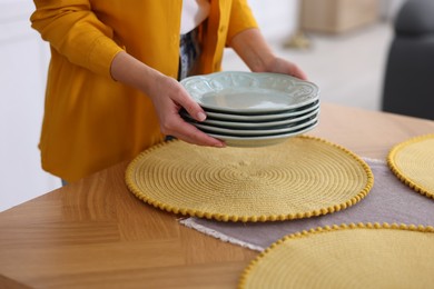 Photo of Woman setting table for dinner at home, closeup