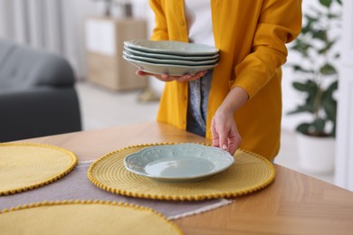 Photo of Woman setting table for dinner at home, closeup