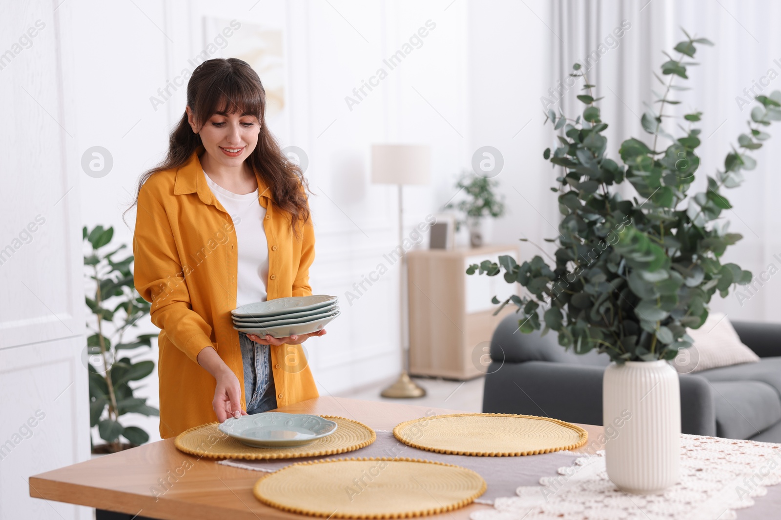 Photo of Woman setting table for dinner at home