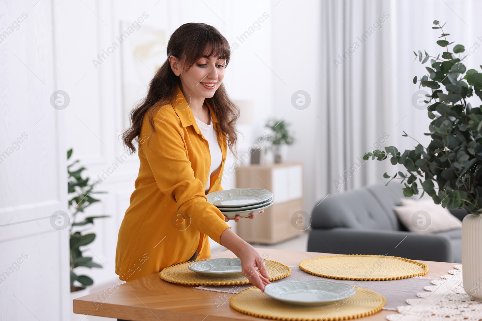 Photo of Woman setting table for dinner at home