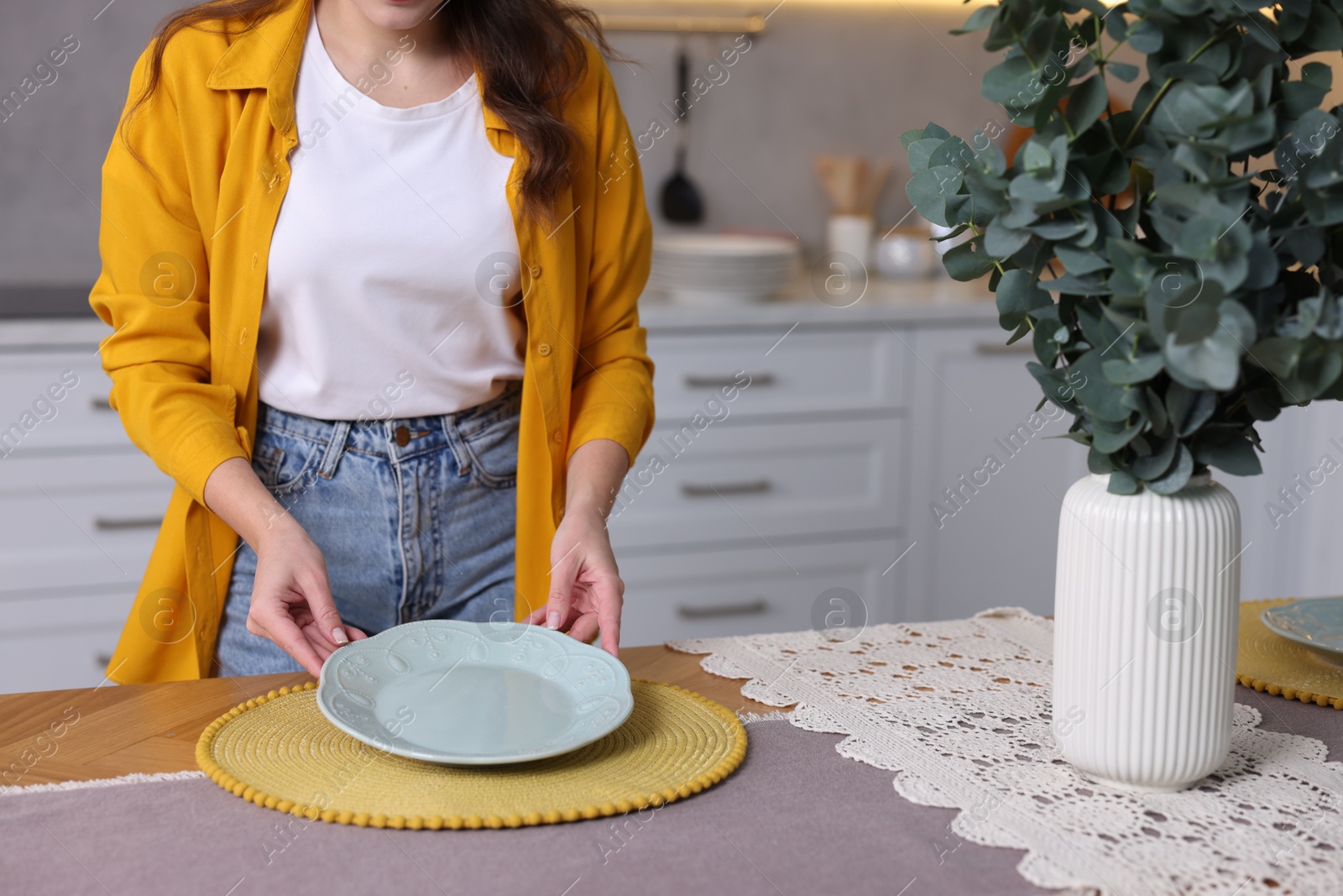 Photo of Woman setting table for dinner at home, closeup