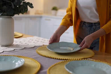 Photo of Woman setting table for dinner at home, closeup