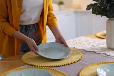 Photo of Woman setting table for dinner at home, closeup