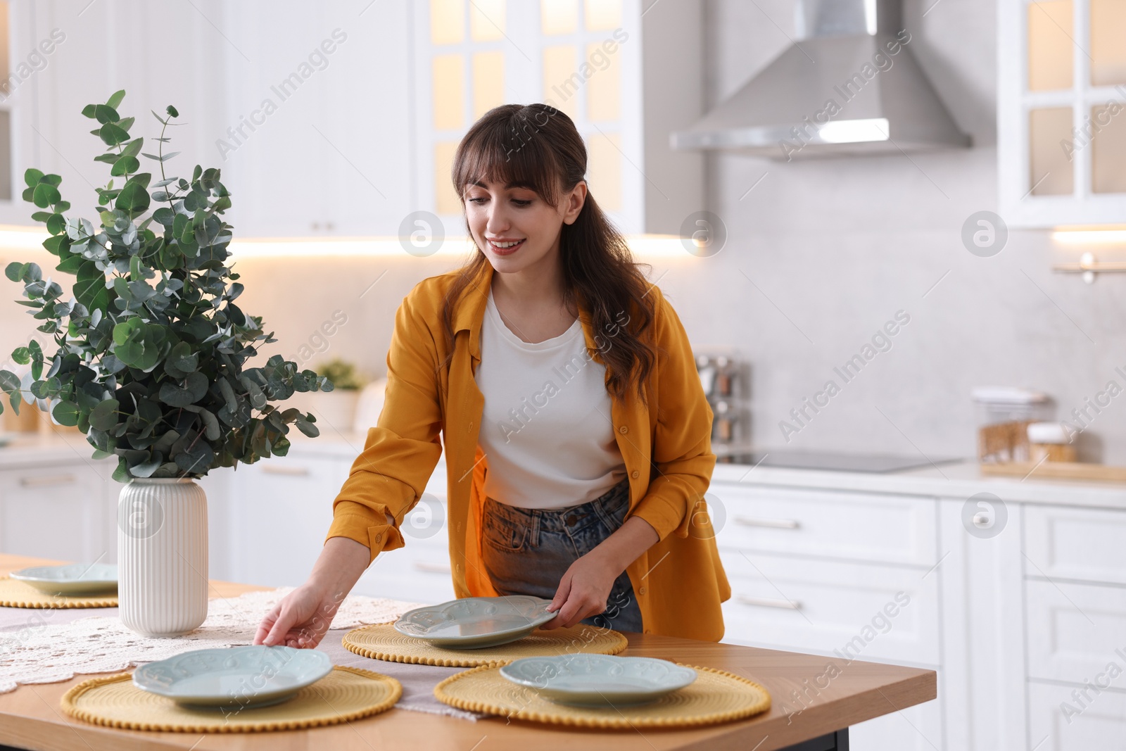 Photo of Woman setting table for dinner at home