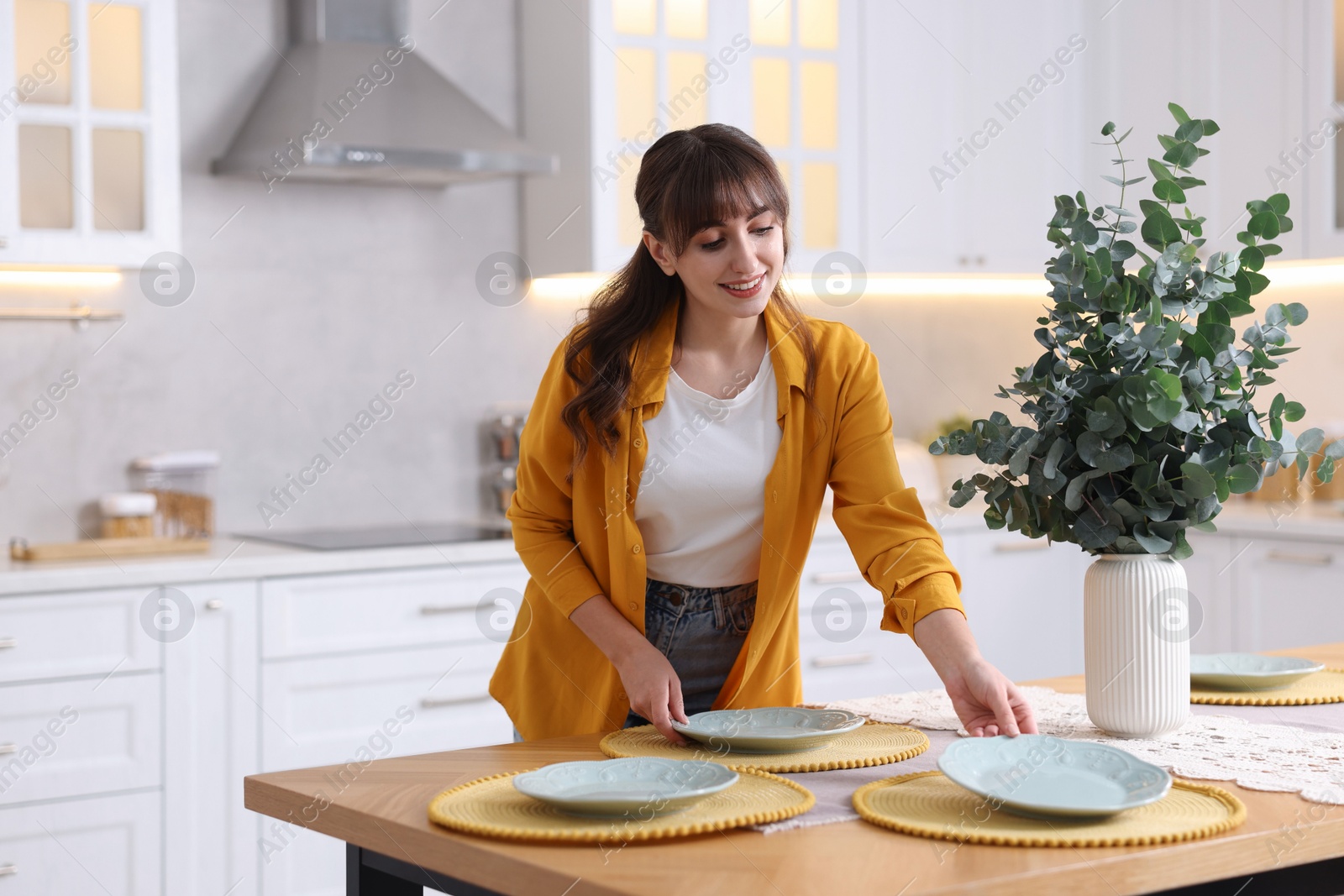 Photo of Woman setting table for dinner at home