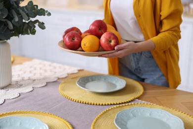 Photo of Woman setting table for dinner at home, closeup