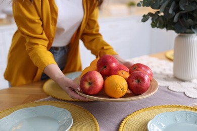 Photo of Woman setting table for dinner at home, closeup