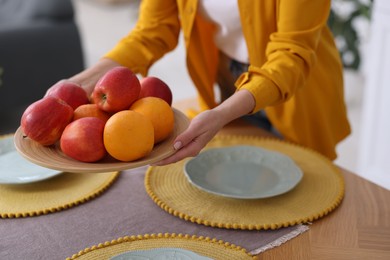 Photo of Woman setting table for dinner at home, closeup