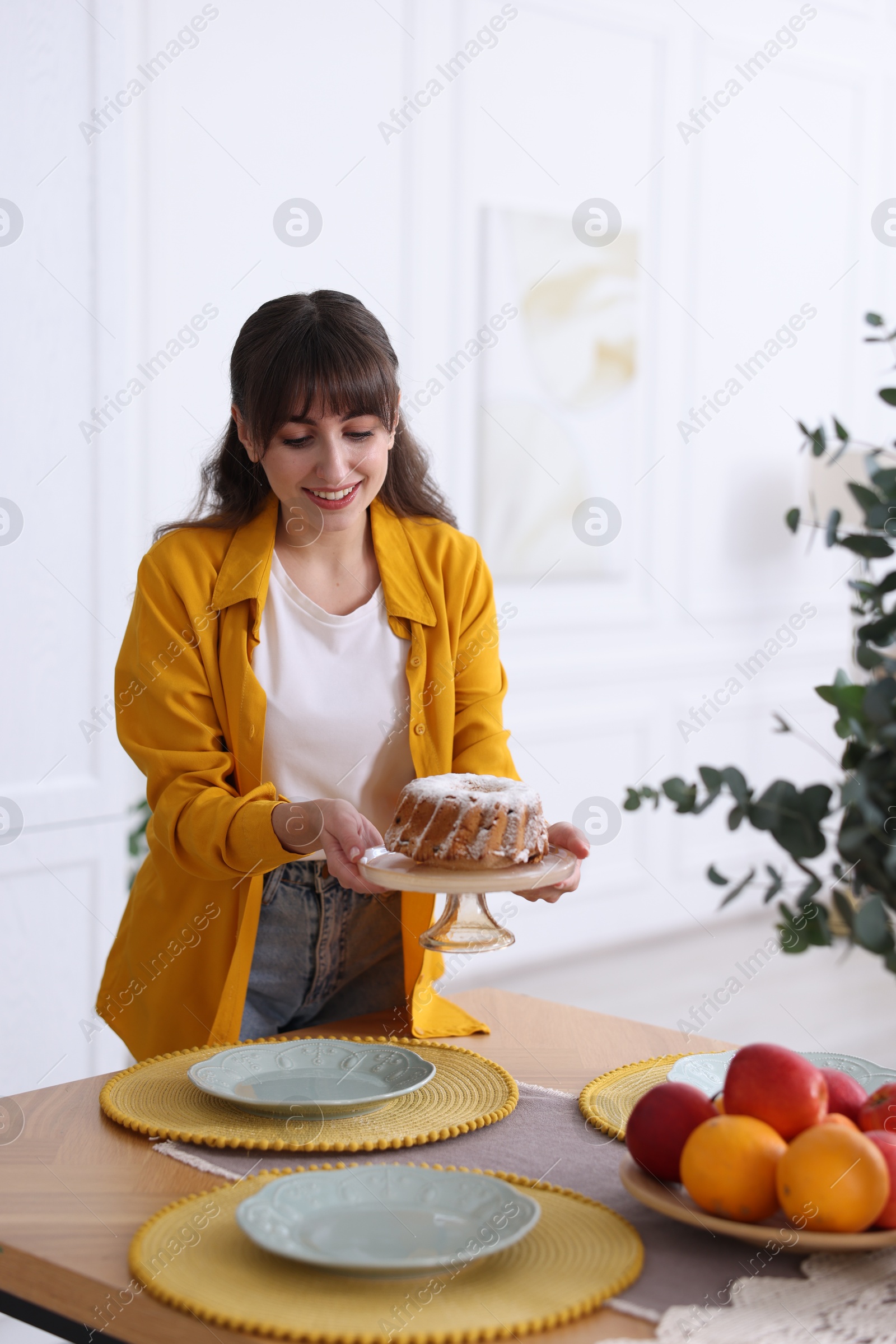 Photo of Woman setting table for dinner at home