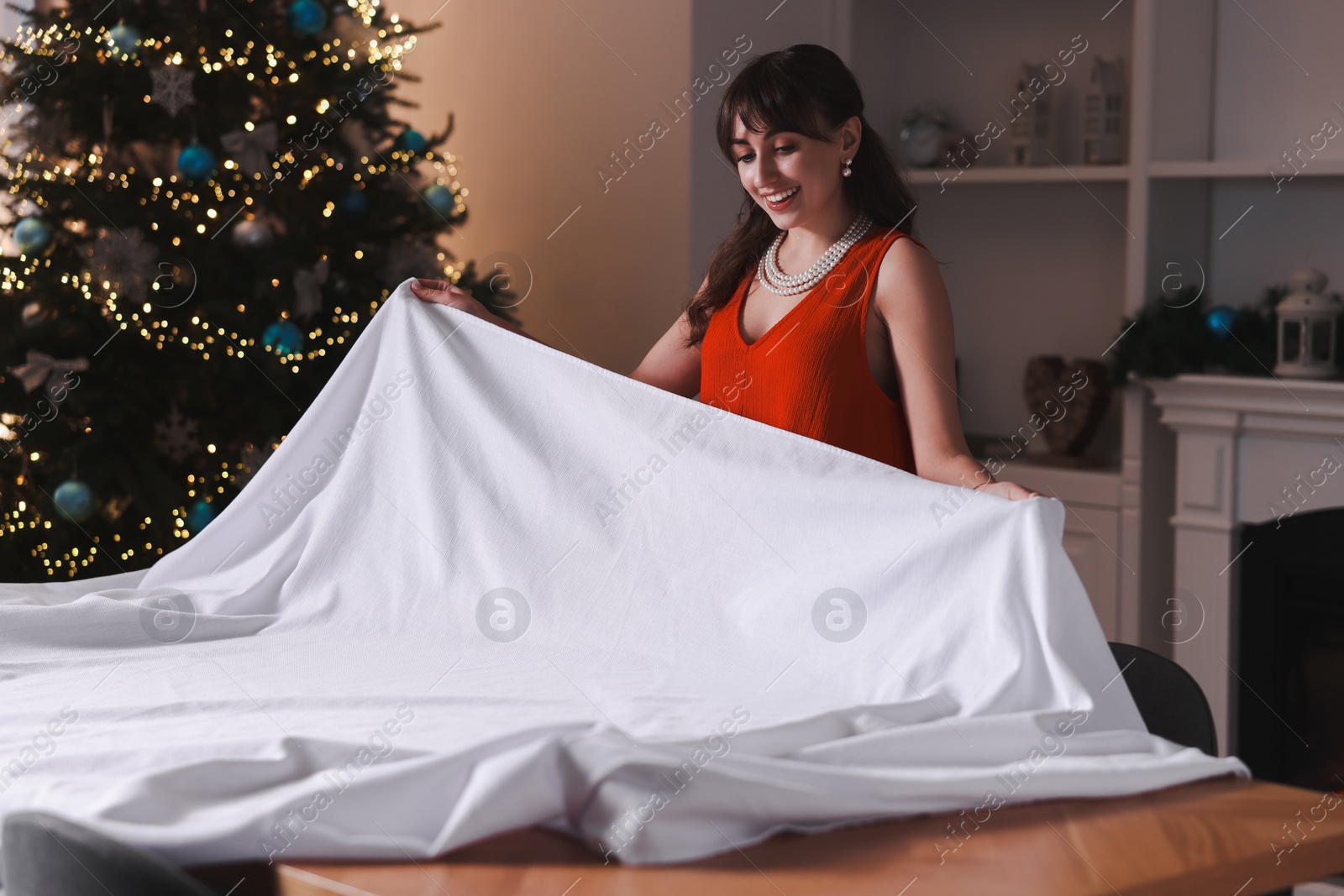 Photo of Woman setting table for Christmas dinner at home