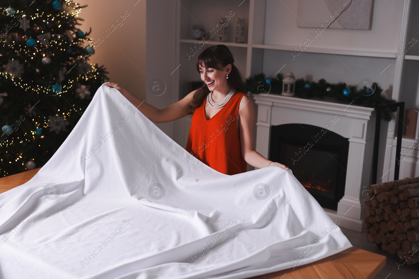 Photo of Woman setting table for Christmas dinner at home