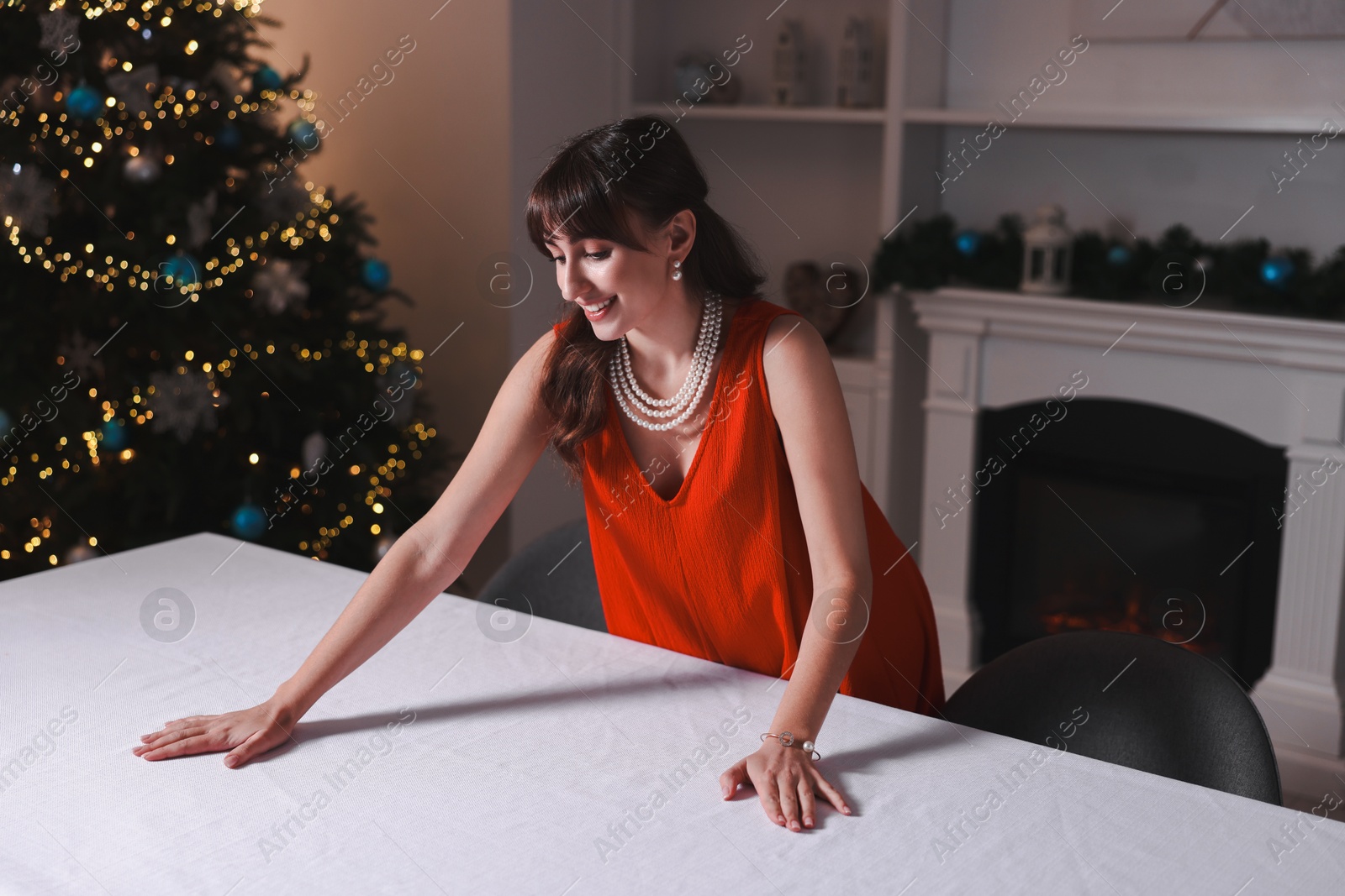 Photo of Woman setting table for Christmas dinner at home