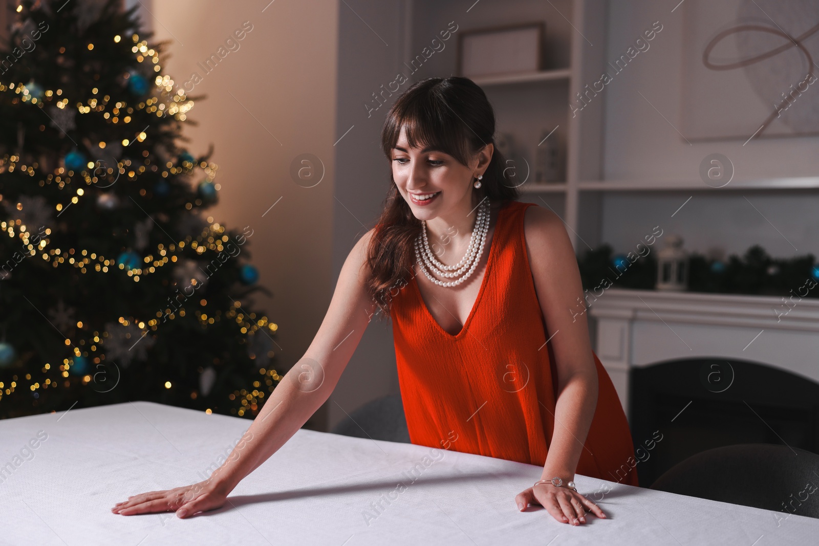 Photo of Woman setting table for Christmas dinner at home