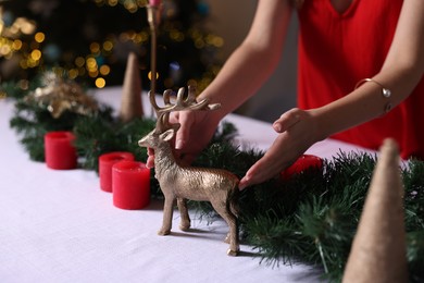 Photo of Woman setting table for Christmas dinner at home, closeup