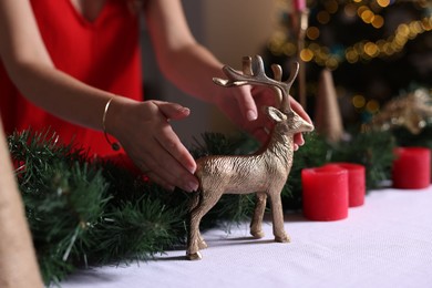 Photo of Woman setting table for Christmas dinner at home, closeup