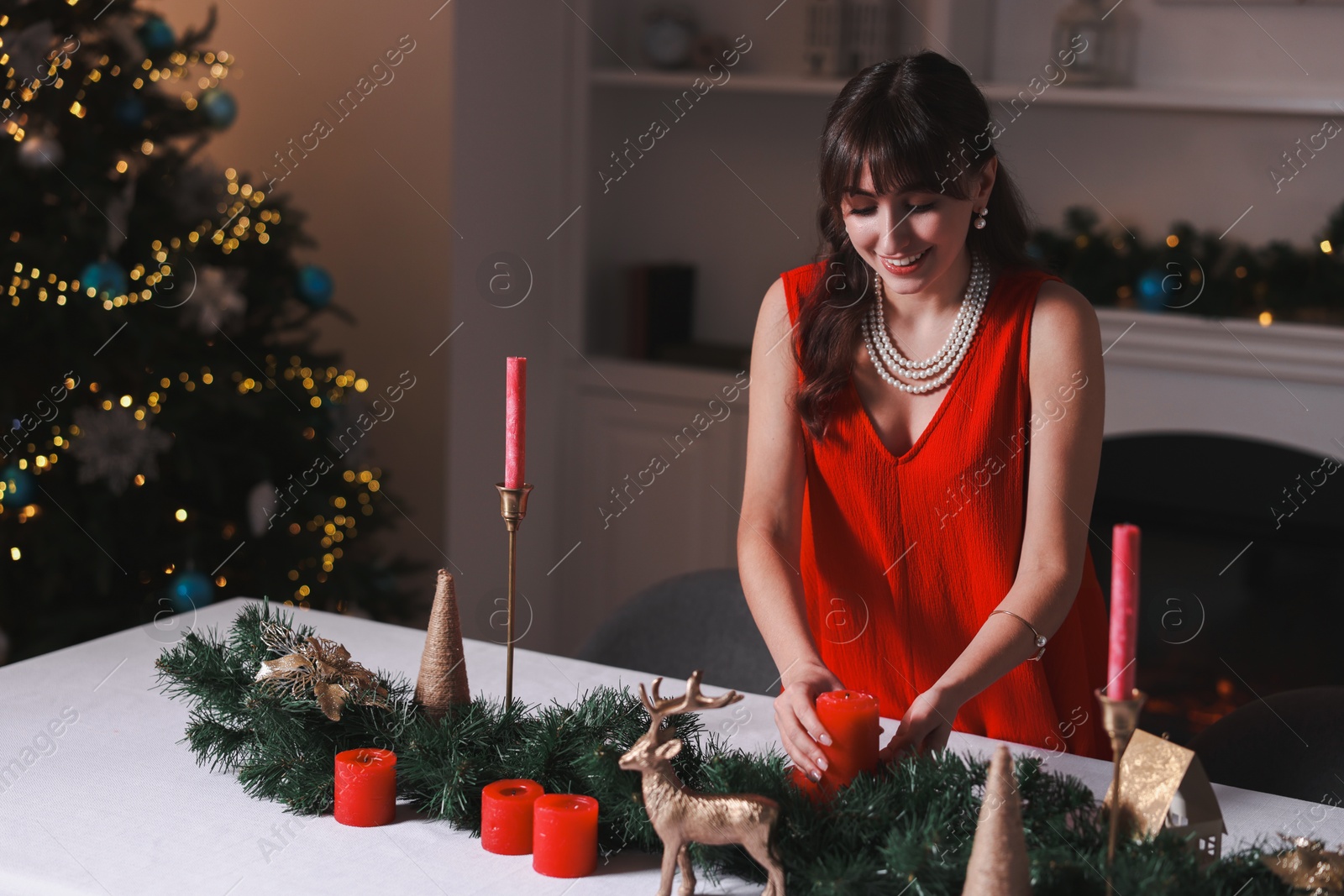 Photo of Woman setting table for Christmas dinner at home, space for text