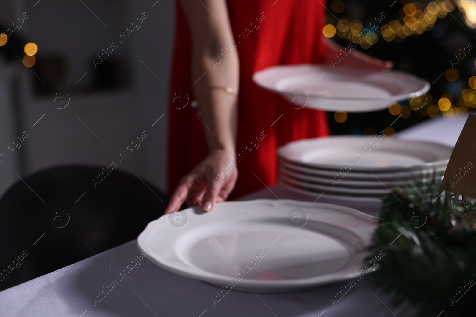 Photo of Woman setting table for Christmas dinner at home, closeup. Space for text