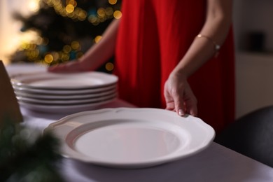 Photo of Woman setting table for Christmas dinner at home, closeup