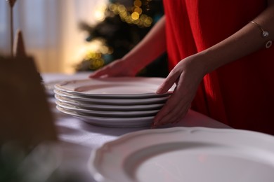 Photo of Woman setting table for Christmas dinner at home, closeup