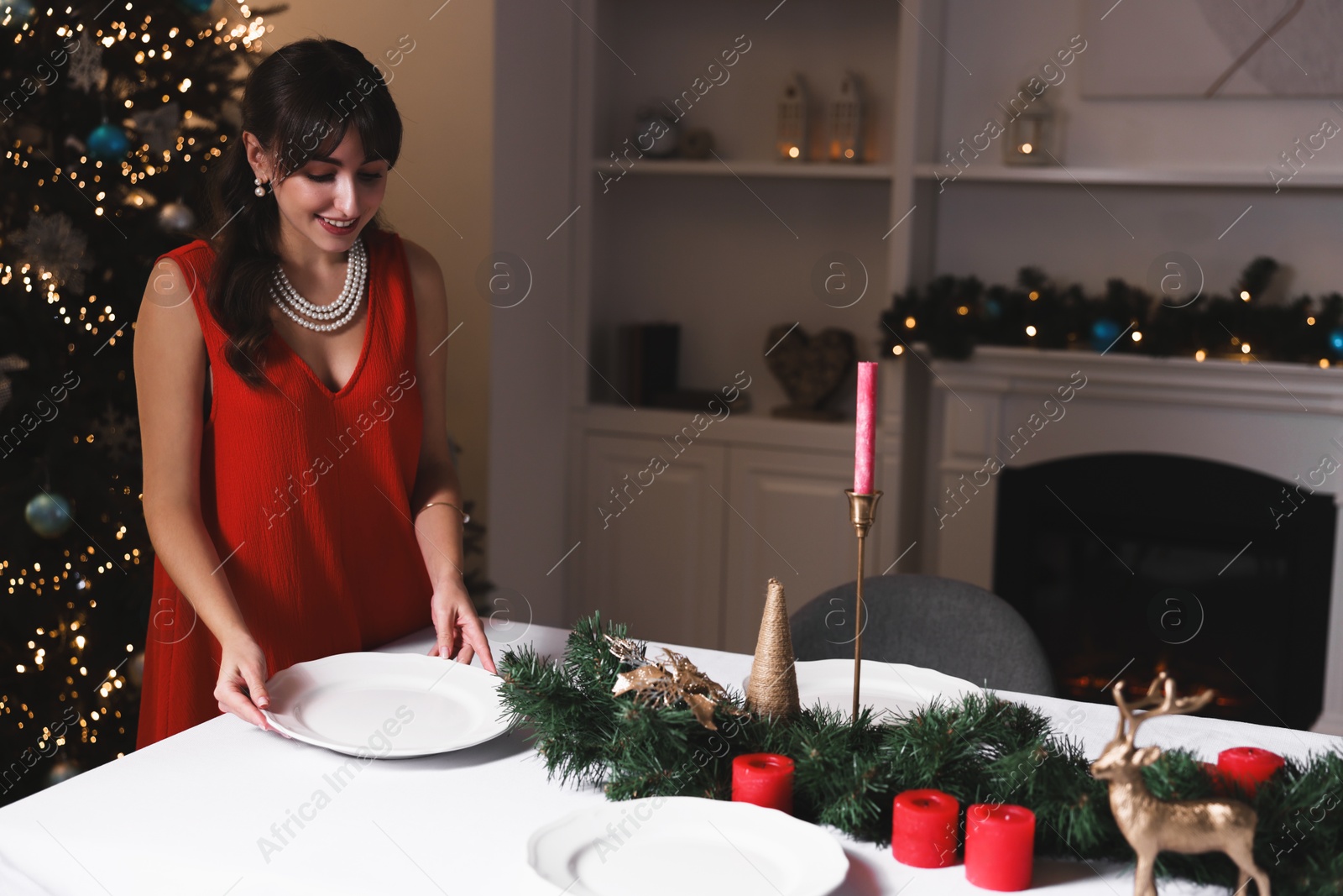 Photo of Woman setting table for Christmas dinner at home, space for text