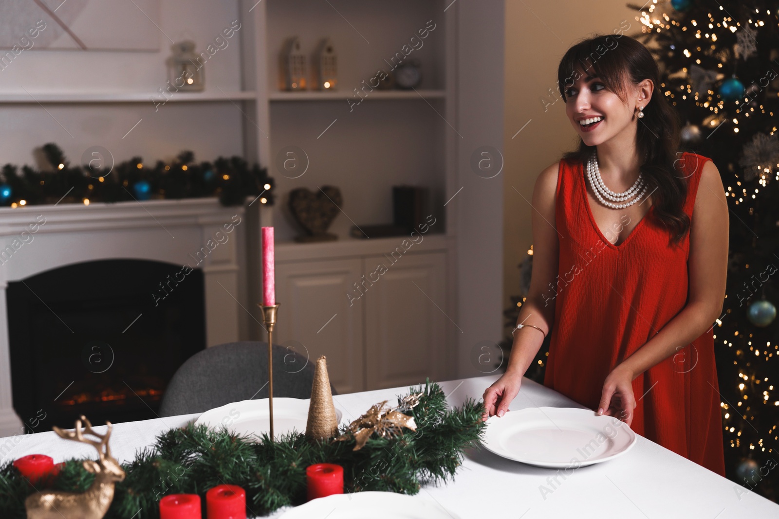 Photo of Woman setting table for Christmas dinner at home, space for text