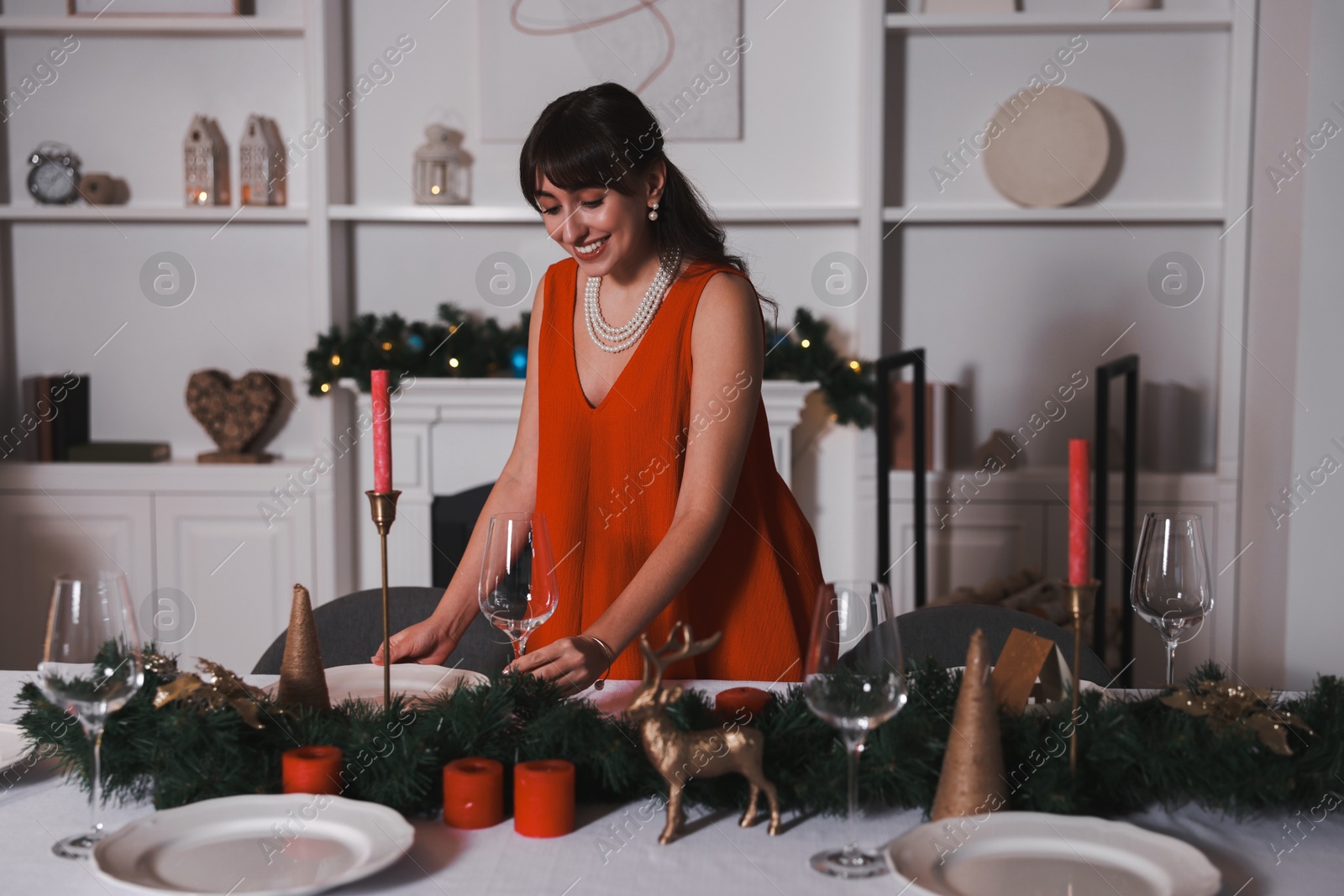 Photo of Woman setting table for Christmas dinner at home