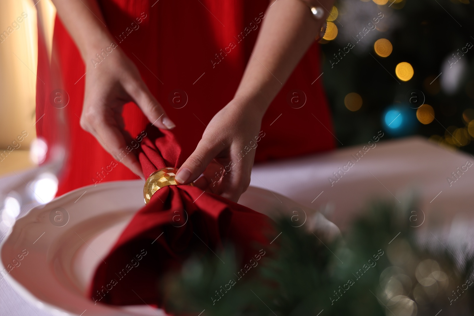 Photo of Woman setting table for Christmas dinner at home, closeup