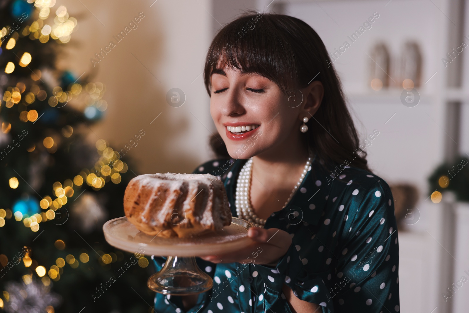 Photo of Woman with delicious sponge cake at home