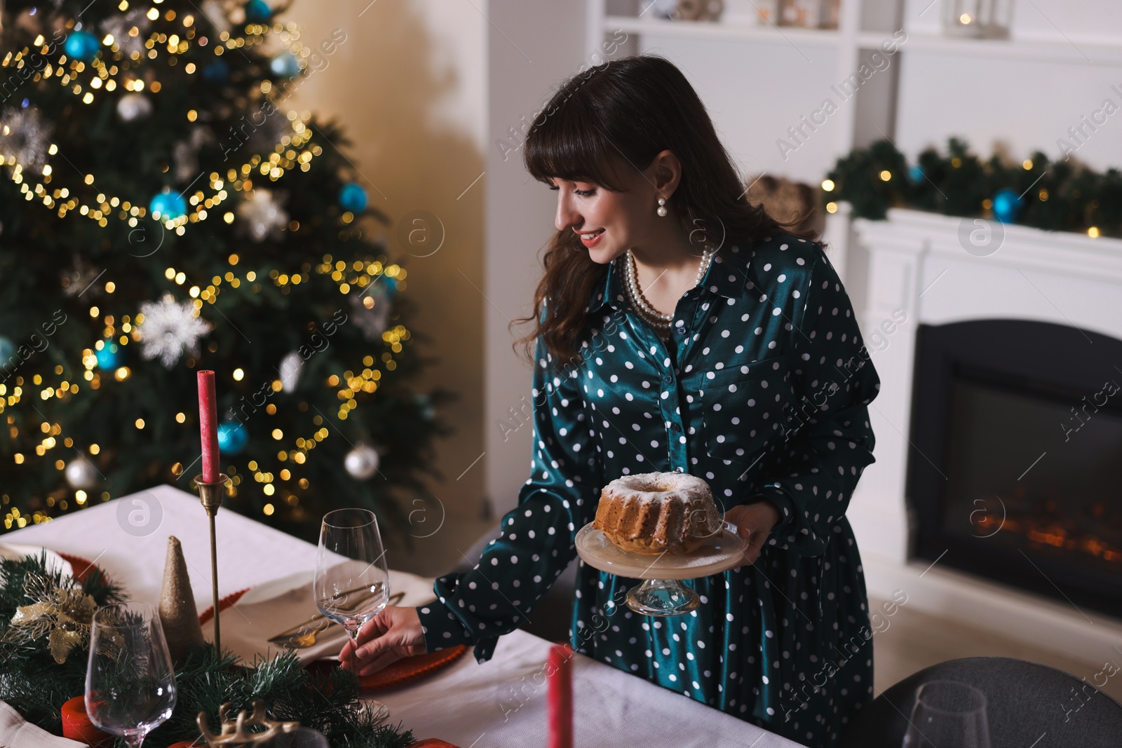 Photo of Woman setting table for Christmas dinner at home