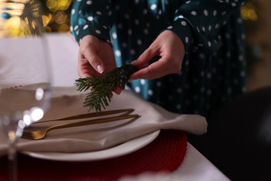 Photo of Woman setting table for Christmas dinner at home, closeup