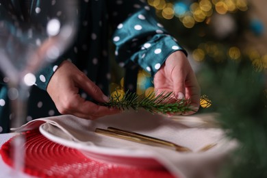 Photo of Woman setting table for Christmas dinner at home, closeup