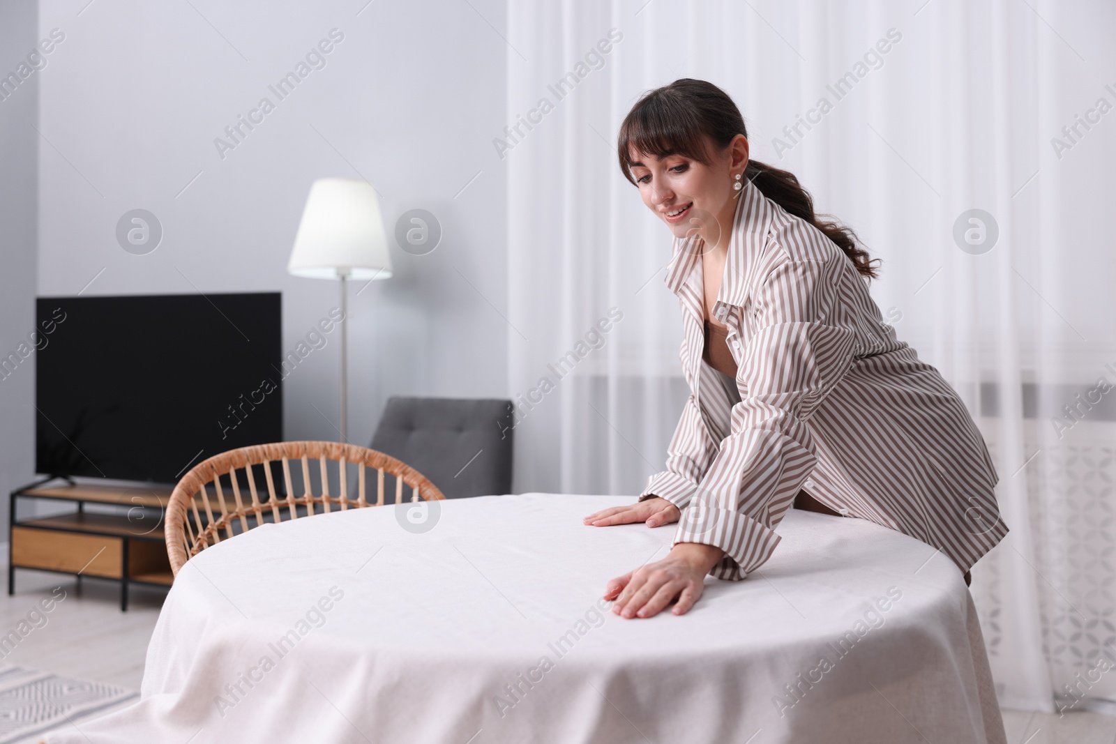 Photo of Woman setting table for dinner at home