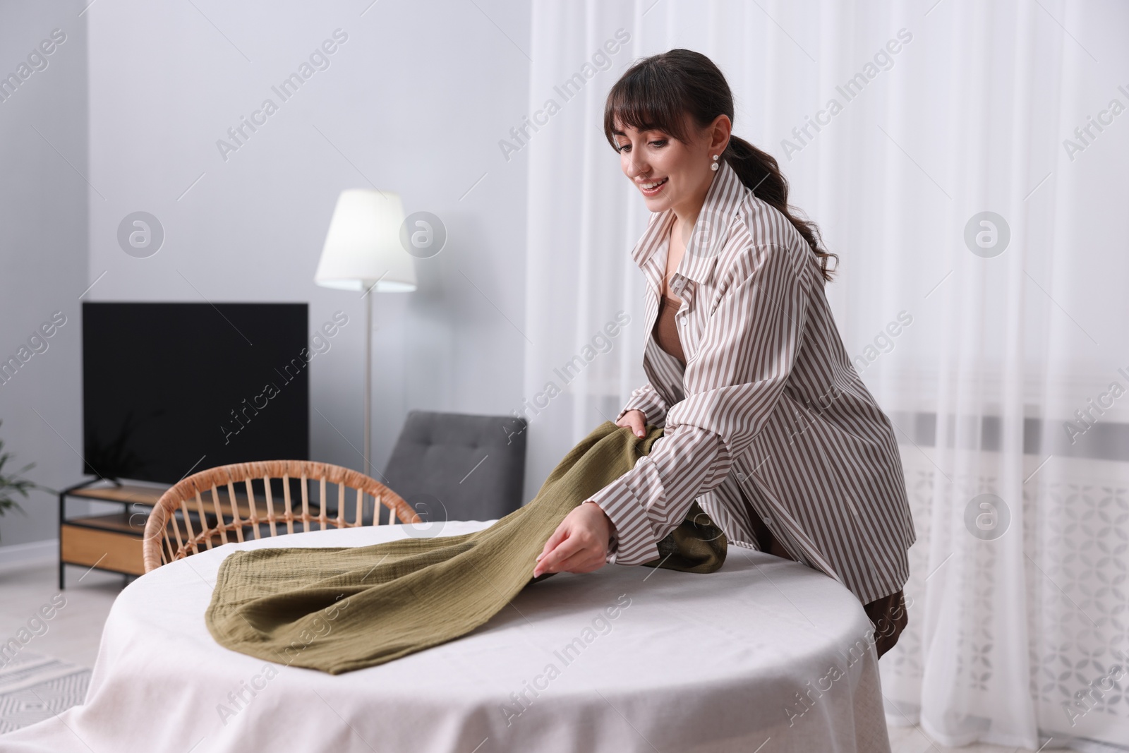 Photo of Woman setting table for dinner at home