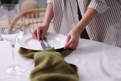 Photo of Woman setting table for dinner at home, closeup